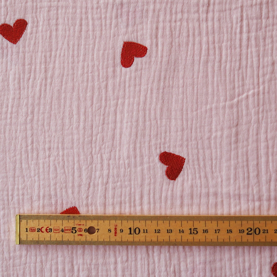 Pink cotton double gauze fabric with embroidered heart pattern for dressmaking