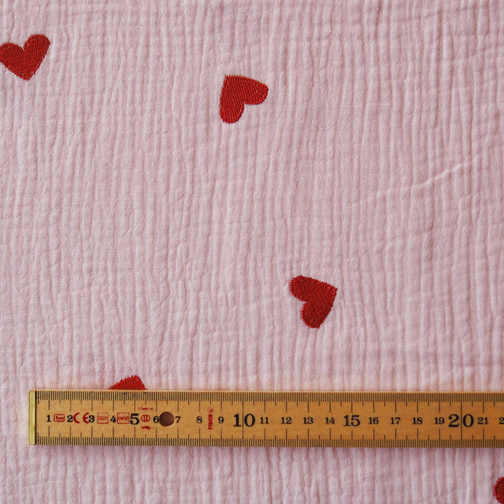 Pink cotton double gauze fabric with embroidered heart pattern for dressmaking