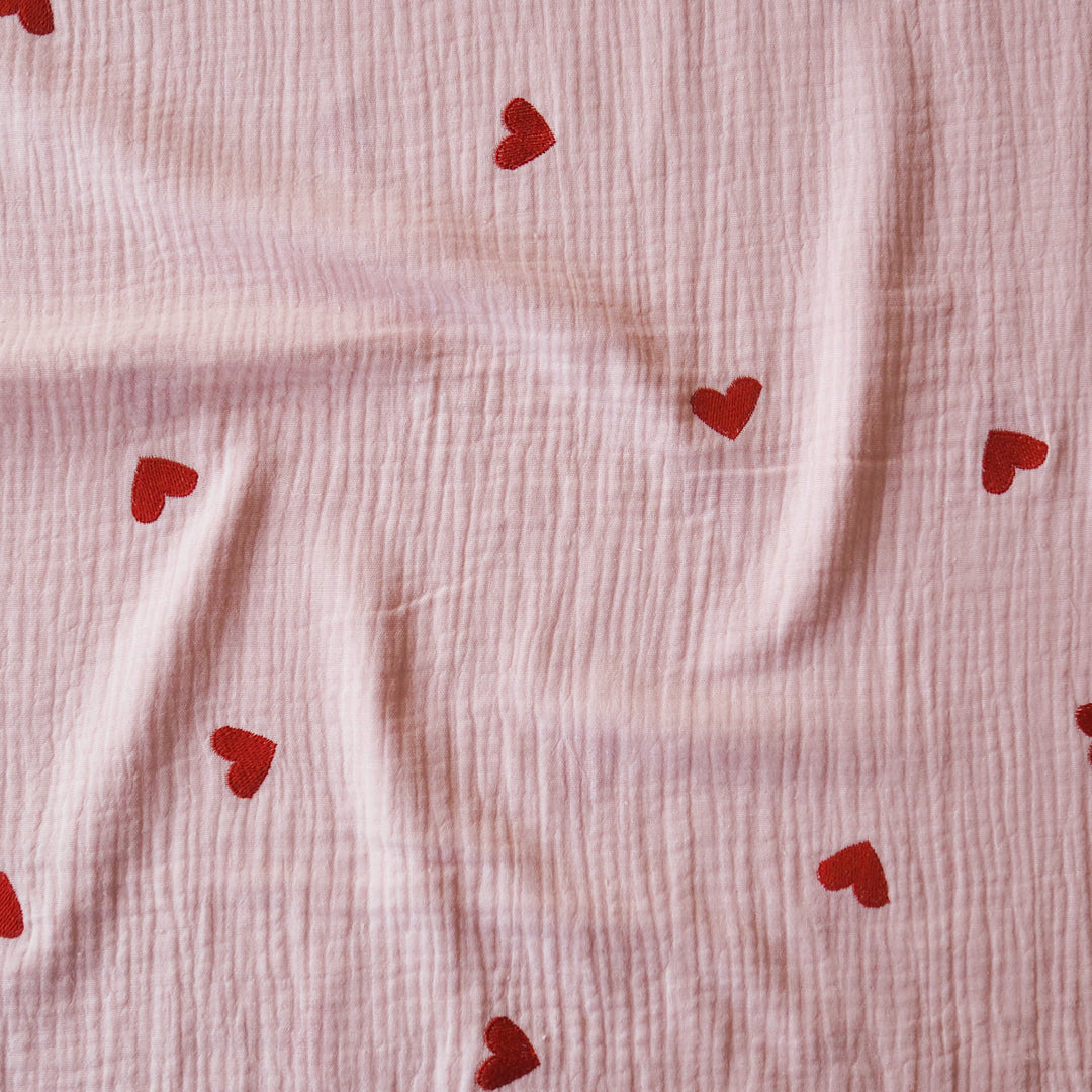 Pink cotton double gauze fabric with embroidered heart pattern for dressmaking