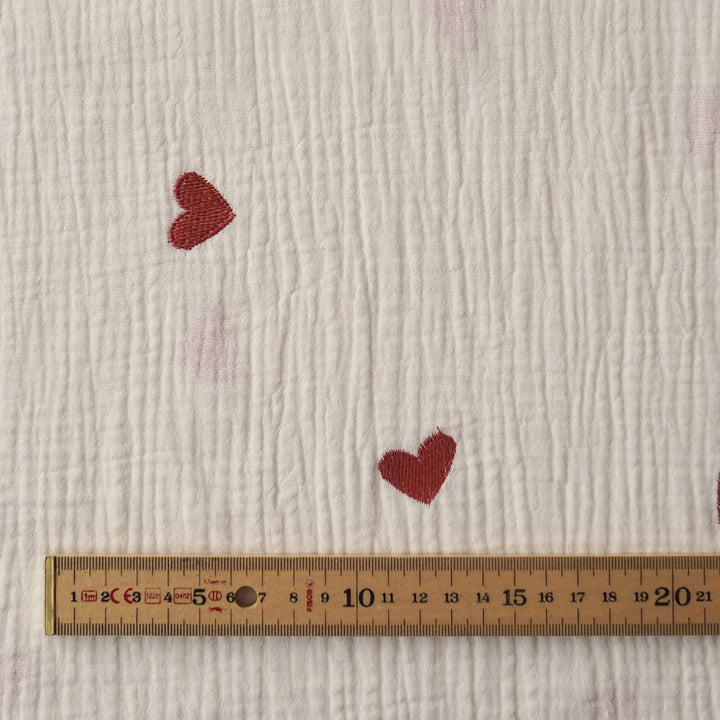 Cream cotton double gauze fabric with embroidered heart pattern for dressmaking