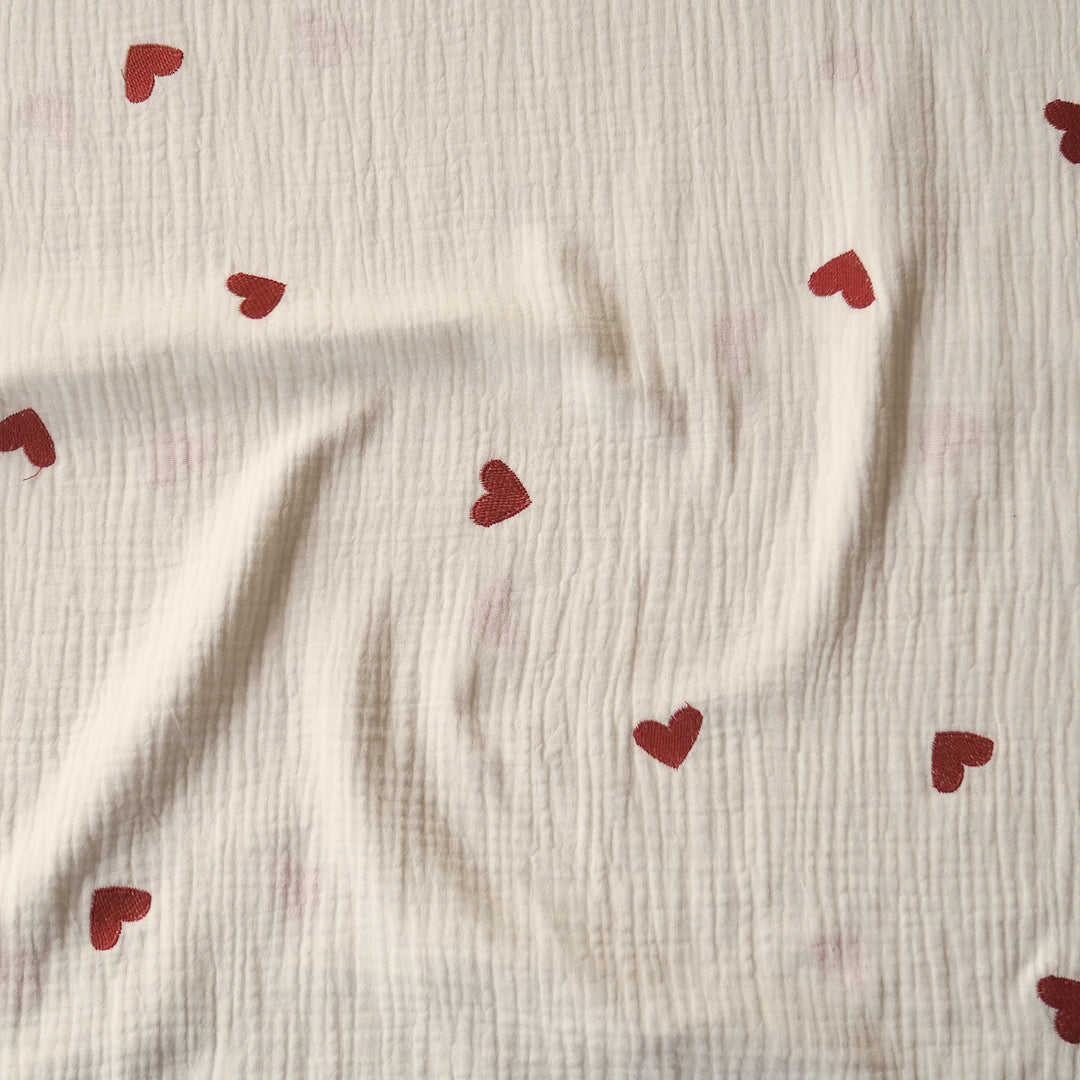 Cream cotton double gauze fabric with embroidered heart pattern for dressmaking