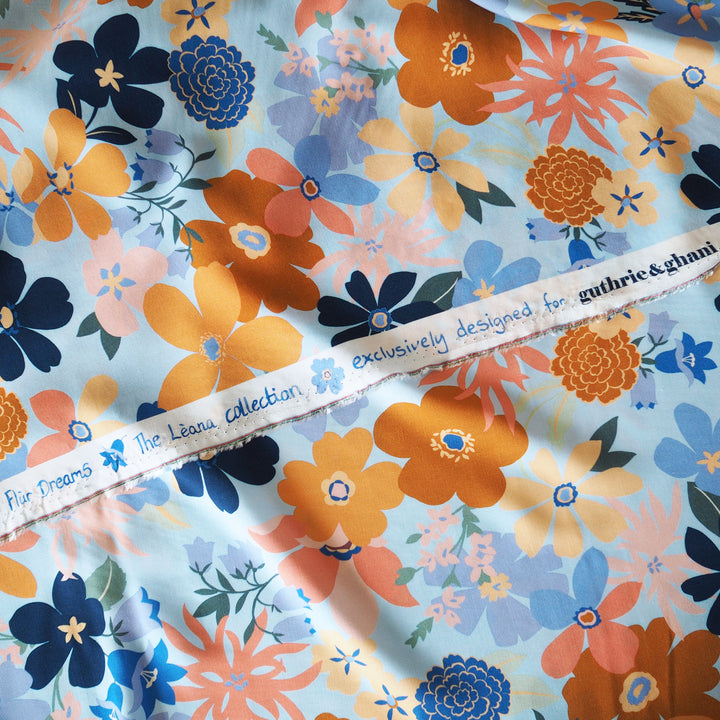 Floral fabric with colorful flowers and a brand label on a blue background