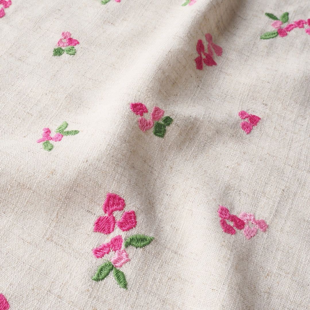 Embroidered pink flowers on beige fabric