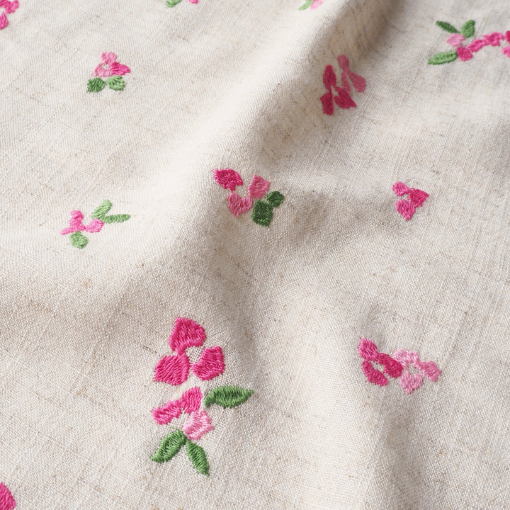 Embroidered pink flowers on beige fabric