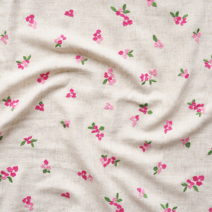 Floral pattern on fabric with pink flowers and green leaves on a beige background