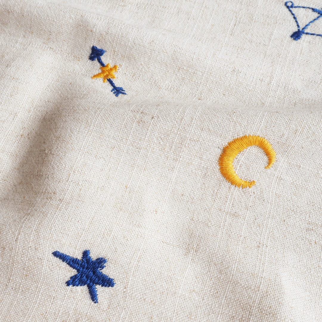Embroidered stars and crescent moon on beige fabric