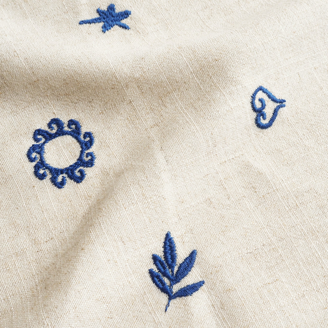 Close-up of beige fabric with blue embroidered patterns