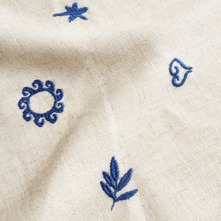 Close-up of beige fabric with blue embroidered patterns