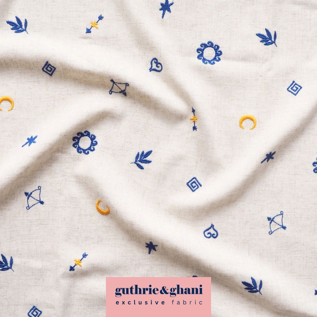 White fabric with embroidered patterns and Guthrie & Ghani logo