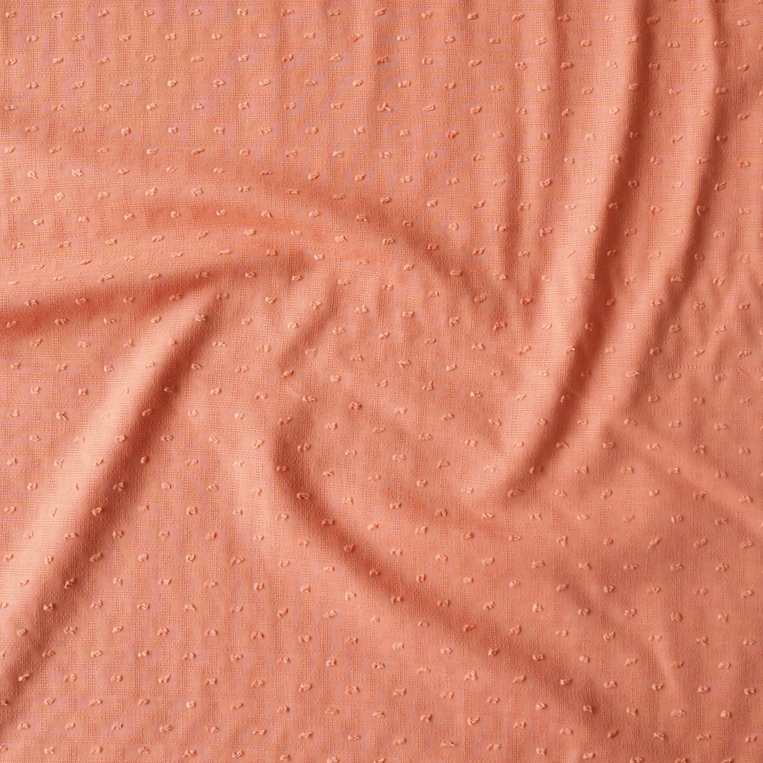 Textured peach fabric with a subtle pattern