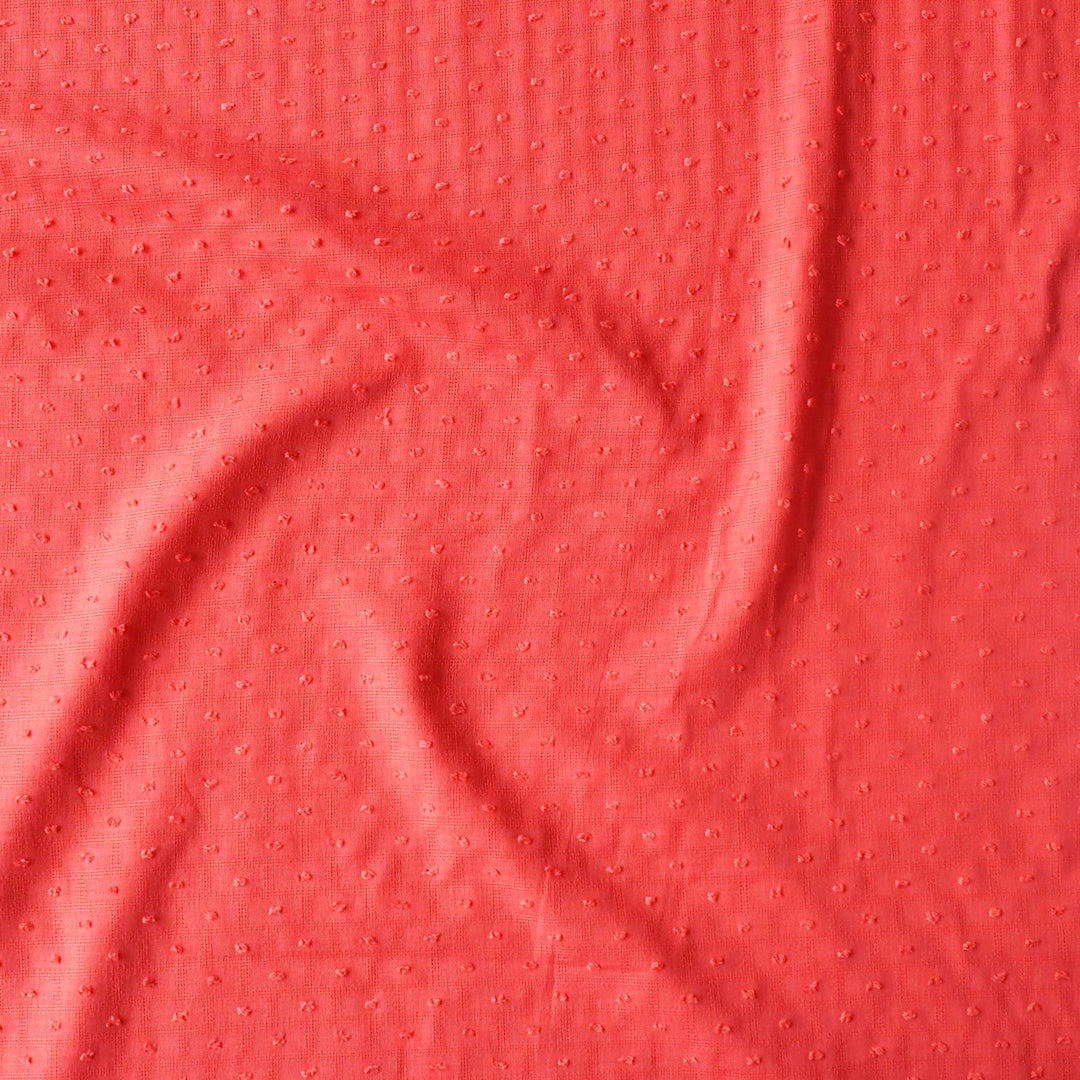 Close-up of coral textured fabric with a subtle pattern