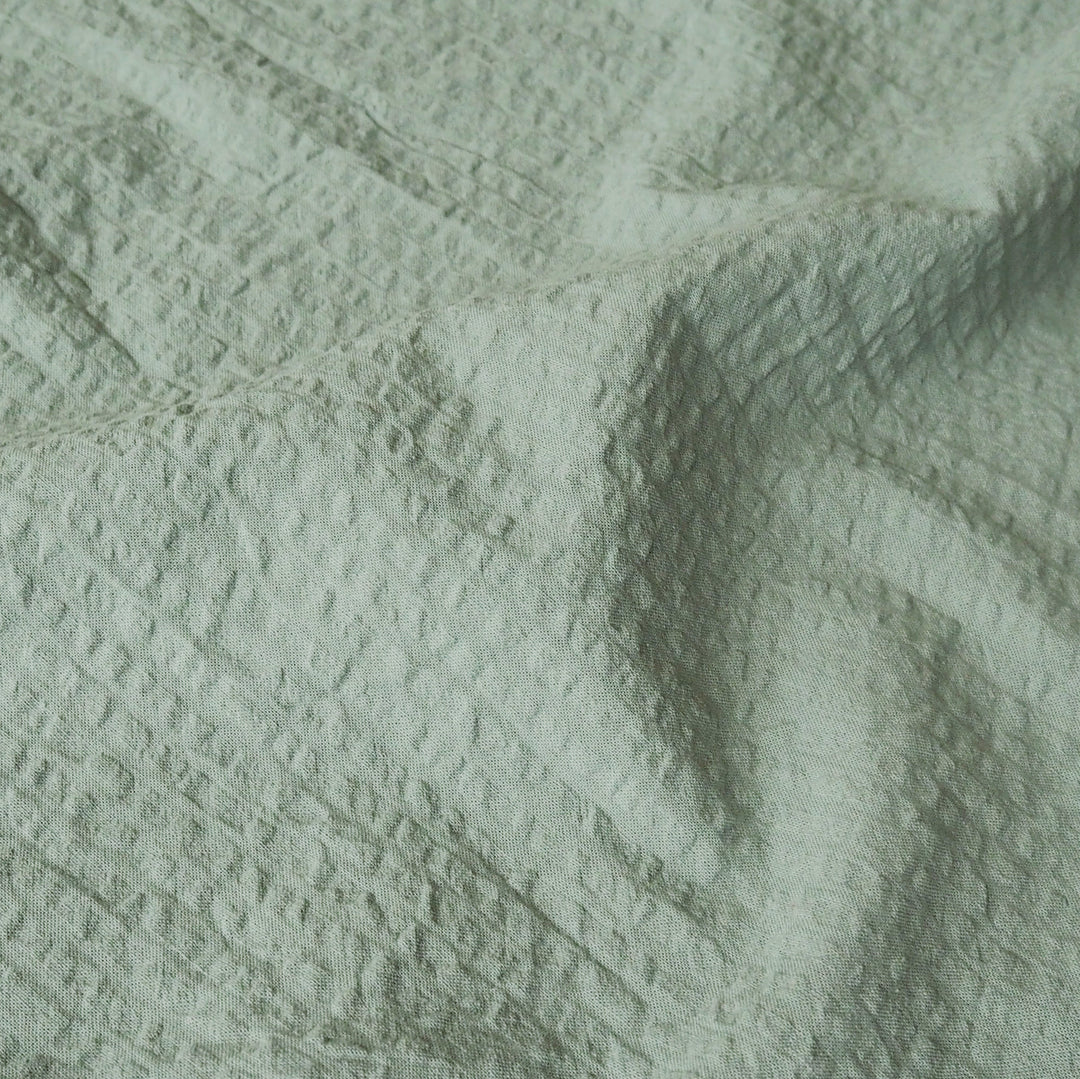 Textured green fabric with a subtle pattern