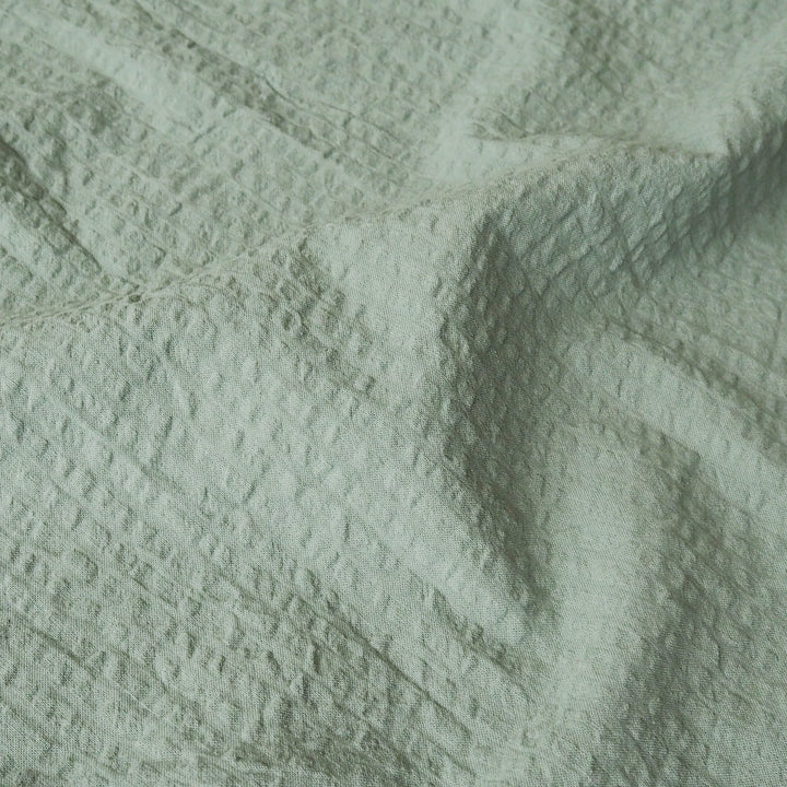 Textured green fabric with a subtle pattern