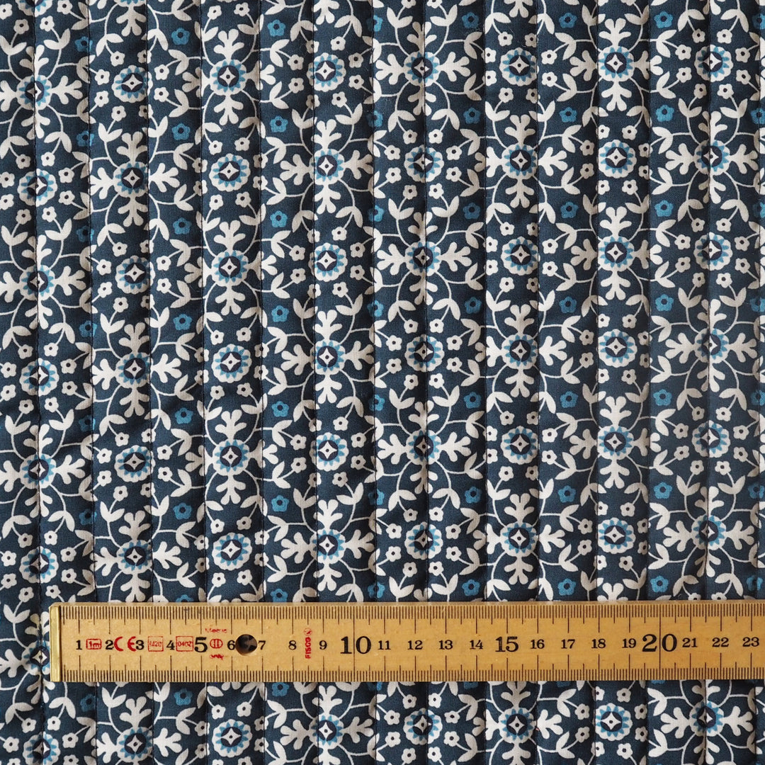 Blue floral patterned fabric with a ruler for scale