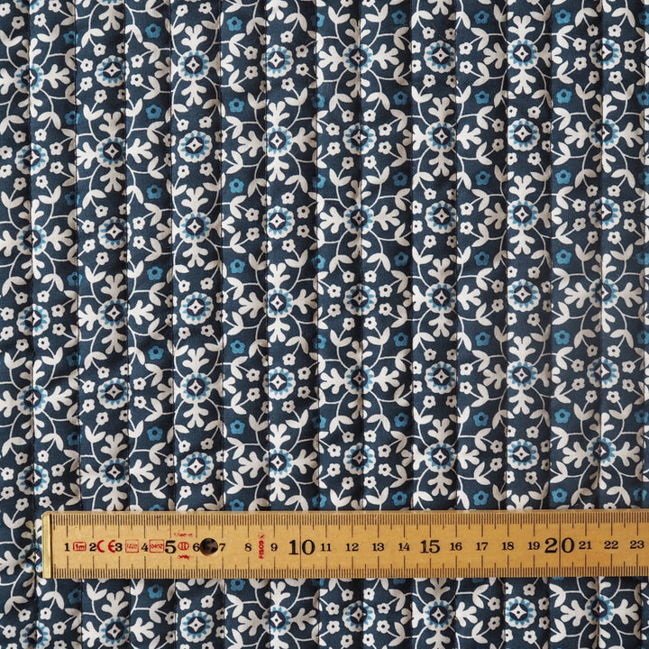 Blue floral patterned fabric with a ruler for scale