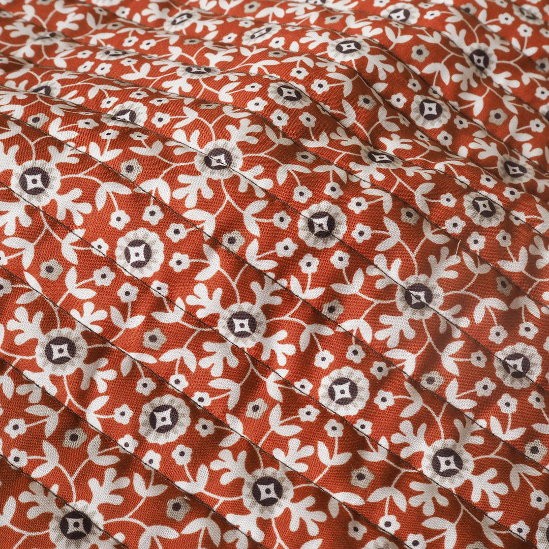 Close-up of a floral patterned fabric with red, white, and brown colors.