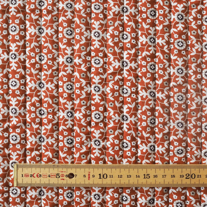 Fabric with a floral pattern and a ruler for scale on a white background