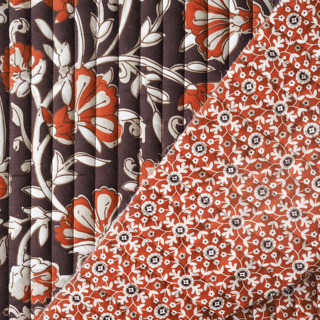 Close-up of floral patterned fabric with rust, white, and brown colours.