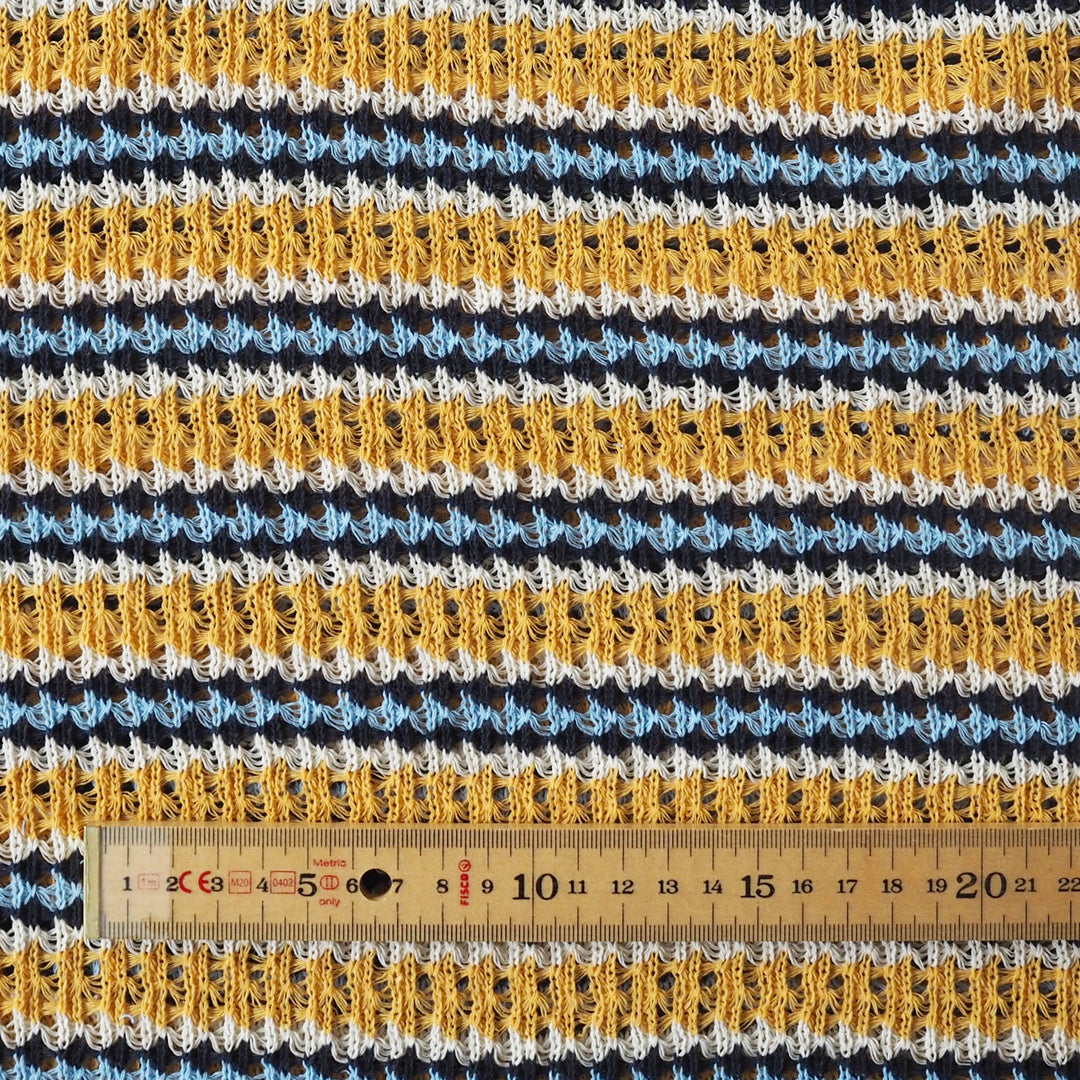 Crocheted fabric with striped pattern and a ruler for scale.