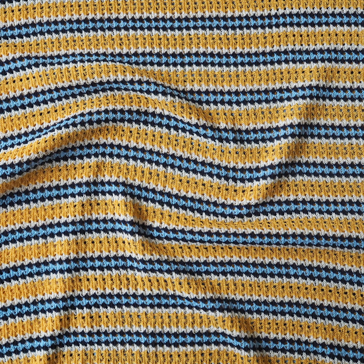 Close-up of striped fabric with yellow, blue, and white pattern