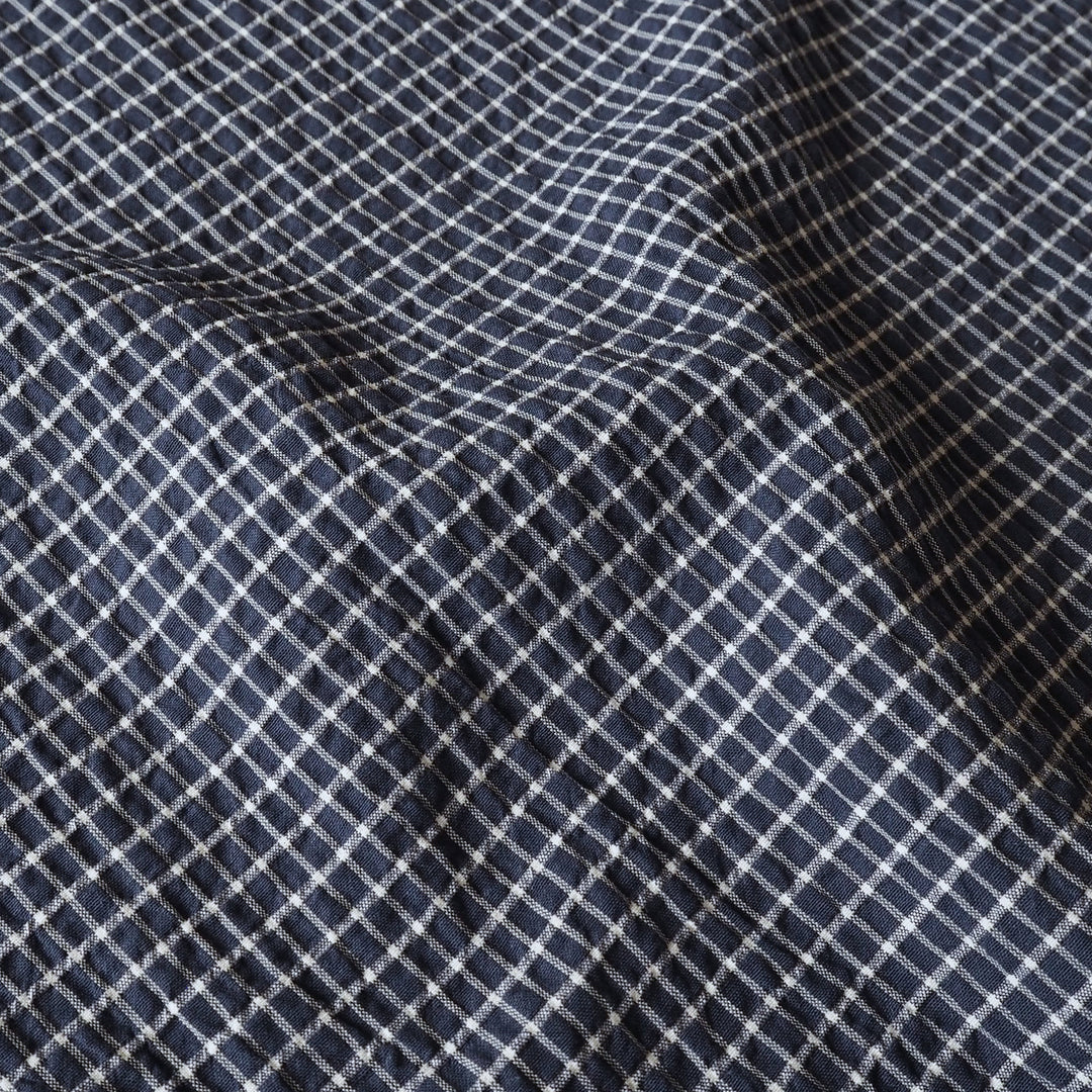 Close-up of dark blue fabric with a white grid pattern