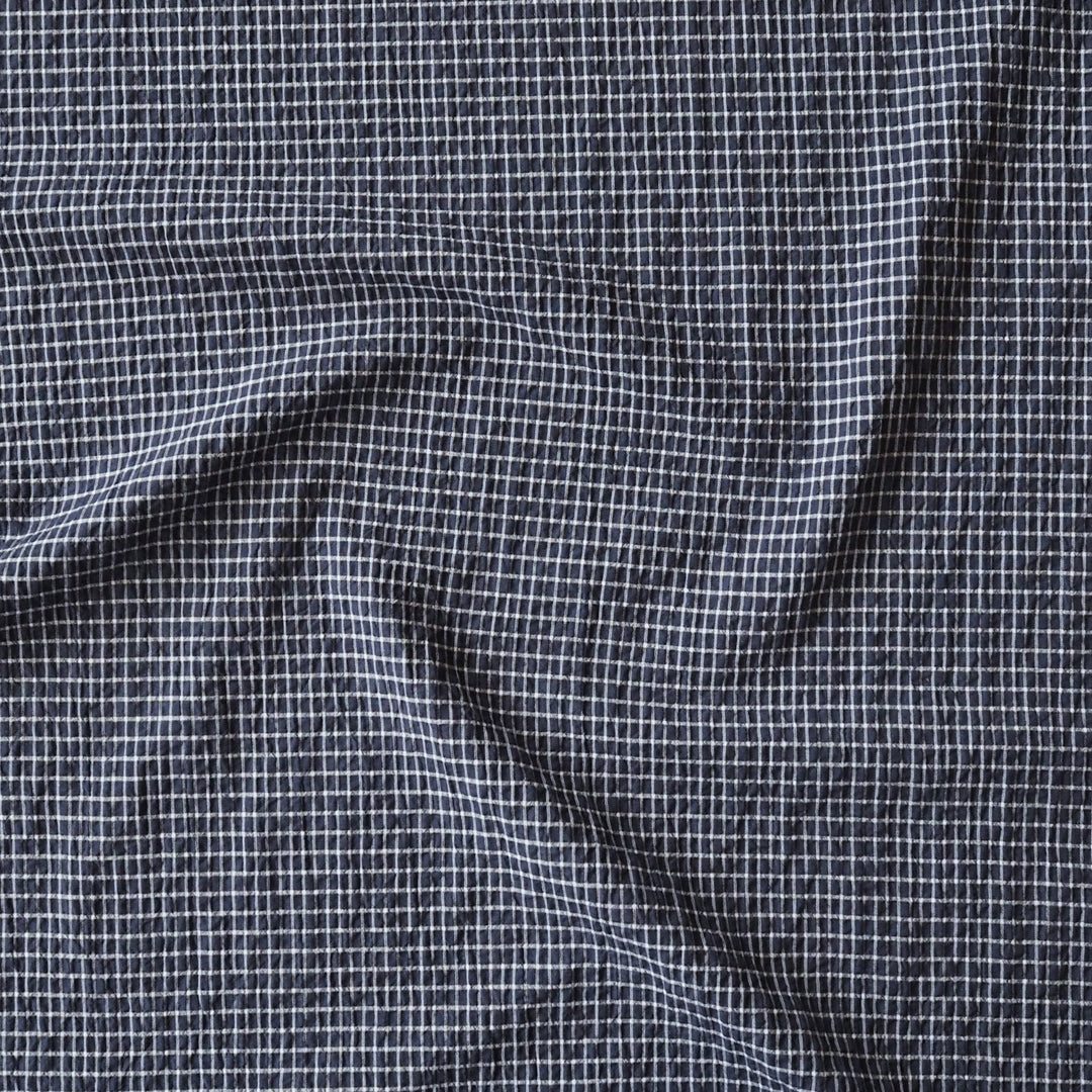 Close-up of checkered fabric with a small white square pattern on a dark background