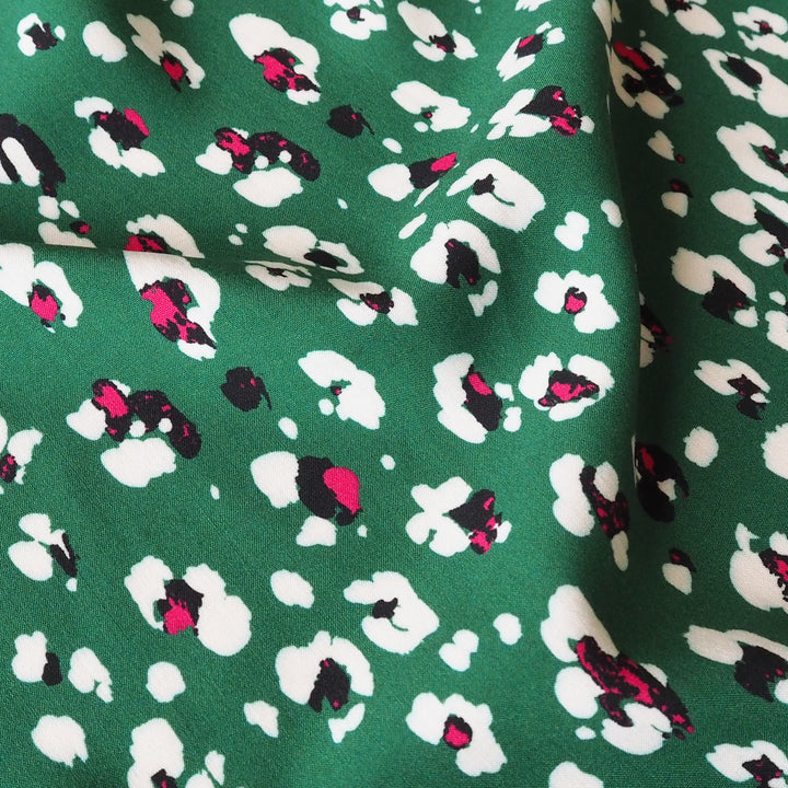 Fabric with an abstract floral pattern on a green background