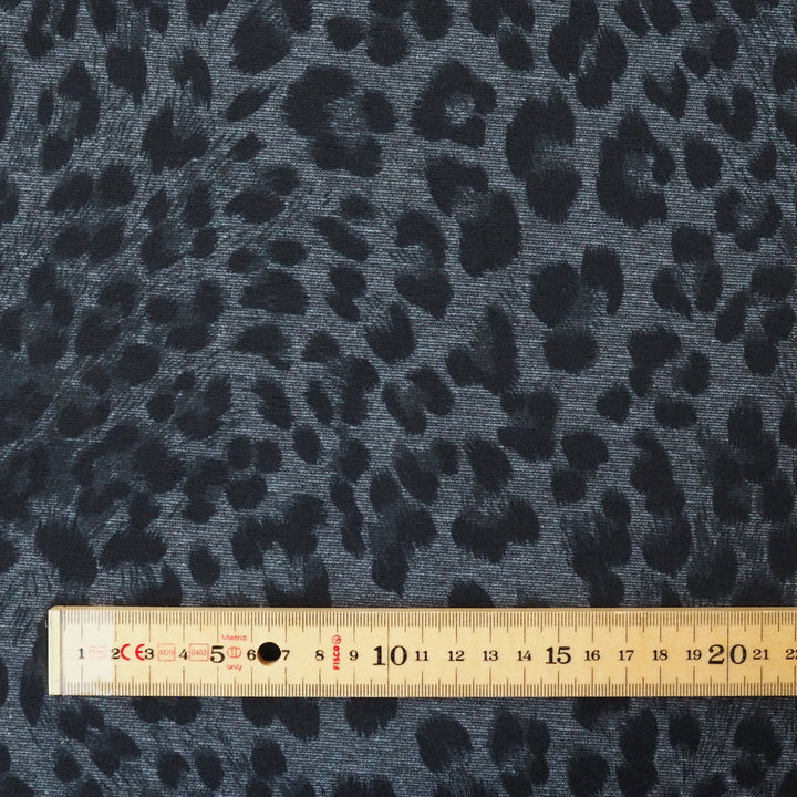 Leopard print fabric with a ruler for scale on a gray background