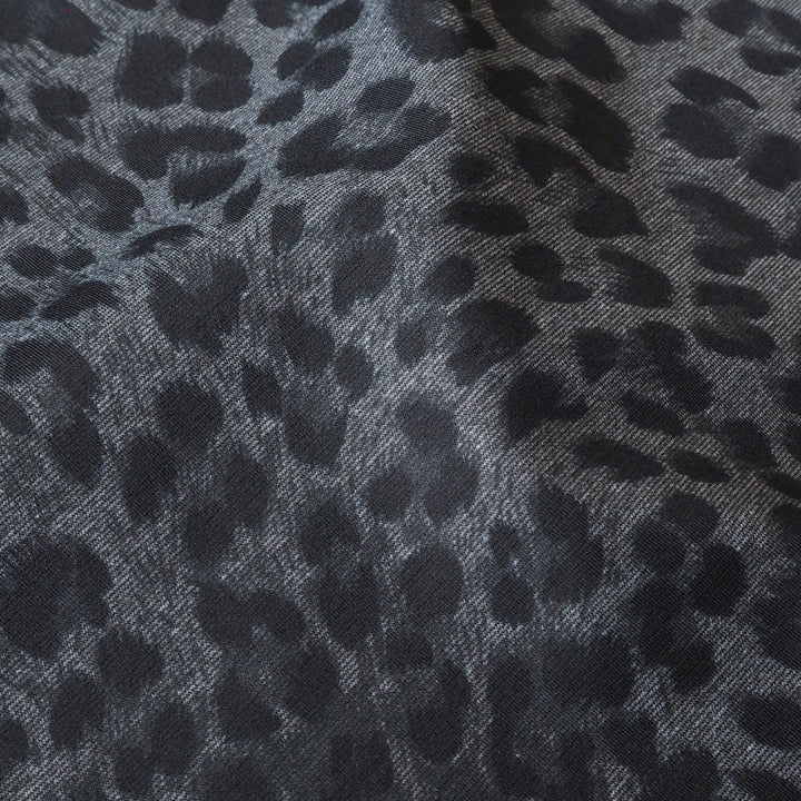 Close-up of gray fabric with black leopard print pattern