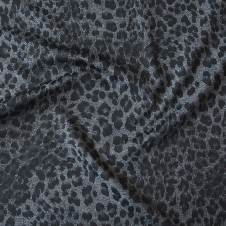 Leopard print fabric with black spots on a gray background