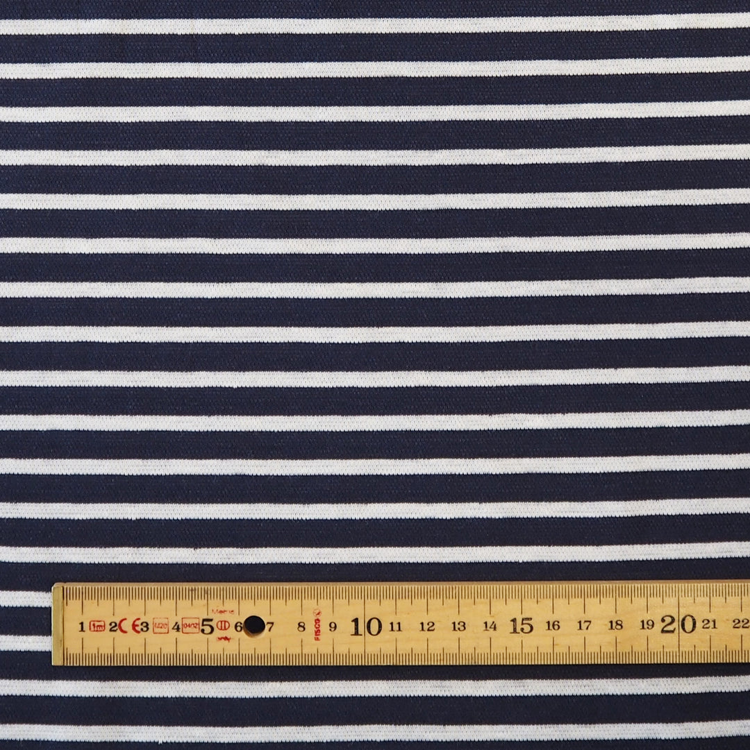 Navy blue and white horizontally striped fabric with a wooden ruler at the bottom for scale.