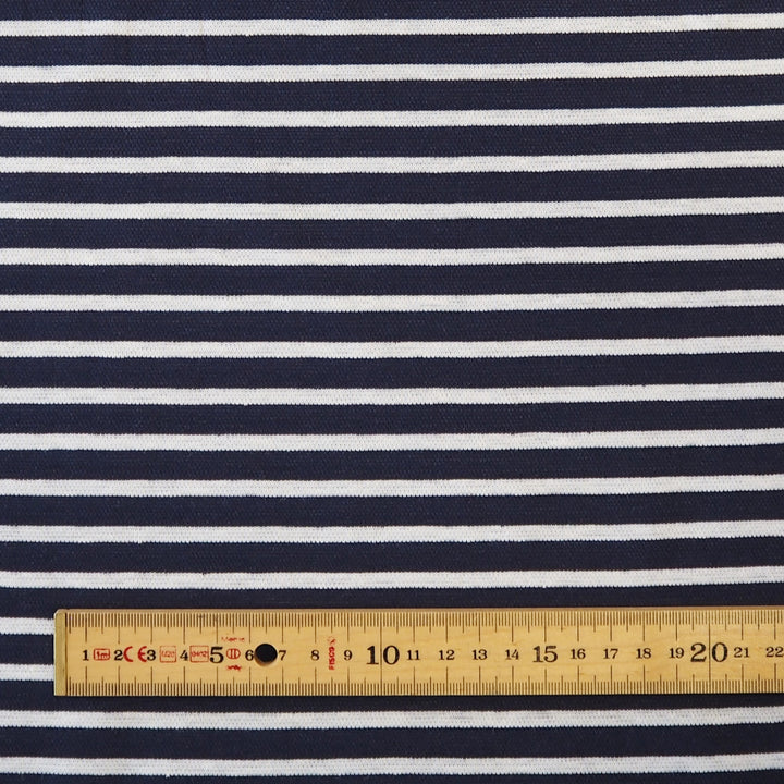 Navy blue and white horizontally striped fabric with a wooden ruler at the bottom for scale.