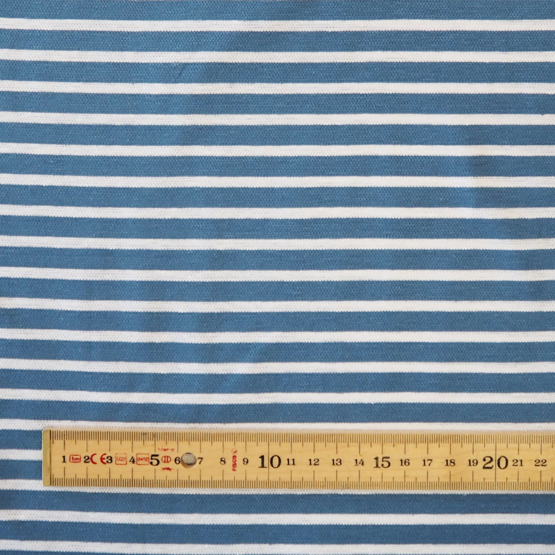 Blue and white striped fabric with a wooden ruler at the bottom for scale.