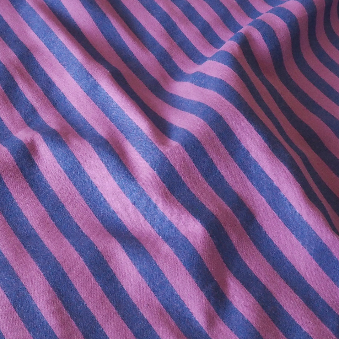 A close-up of a striped fabric with alternating diagonal stripes in purple and dark blue.