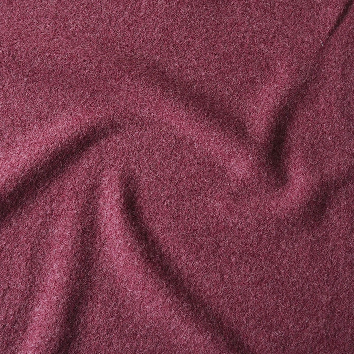 A close-up of draped, textured fabric in a deep wine or burgundy shade, filling the entire frame.