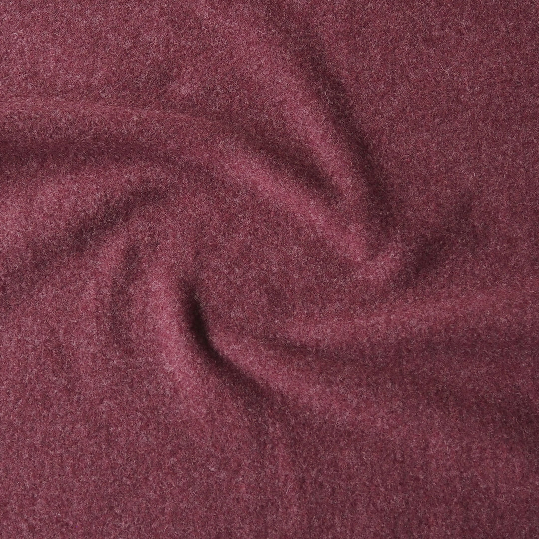 A close-up of heathered burgundy fabric with soft folds and a textured, slightly fuzzy surface.