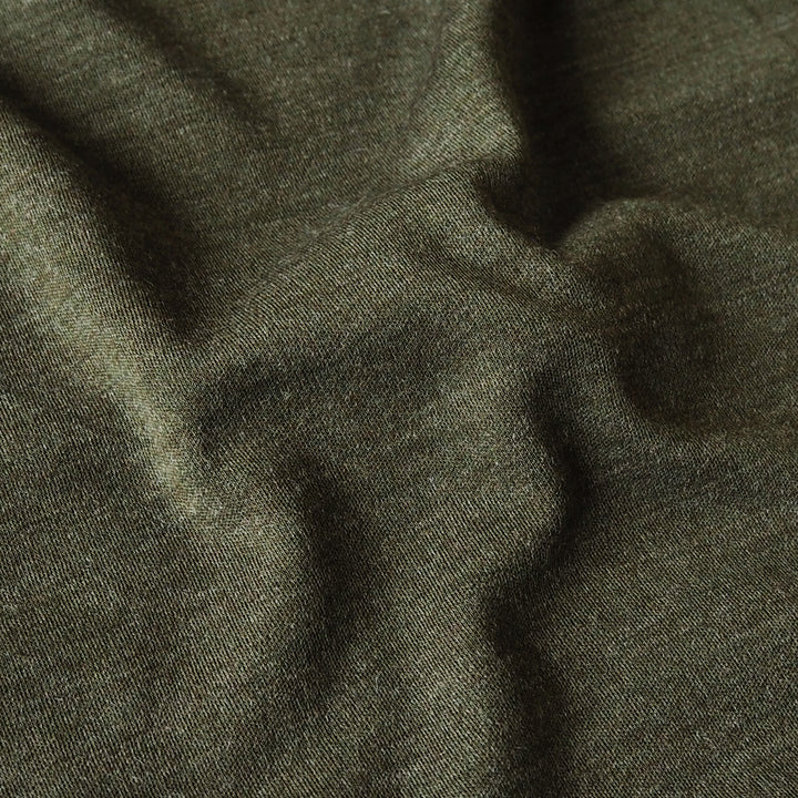 A close-up of dark olive green fabric with a fine textured weave and soft folds.