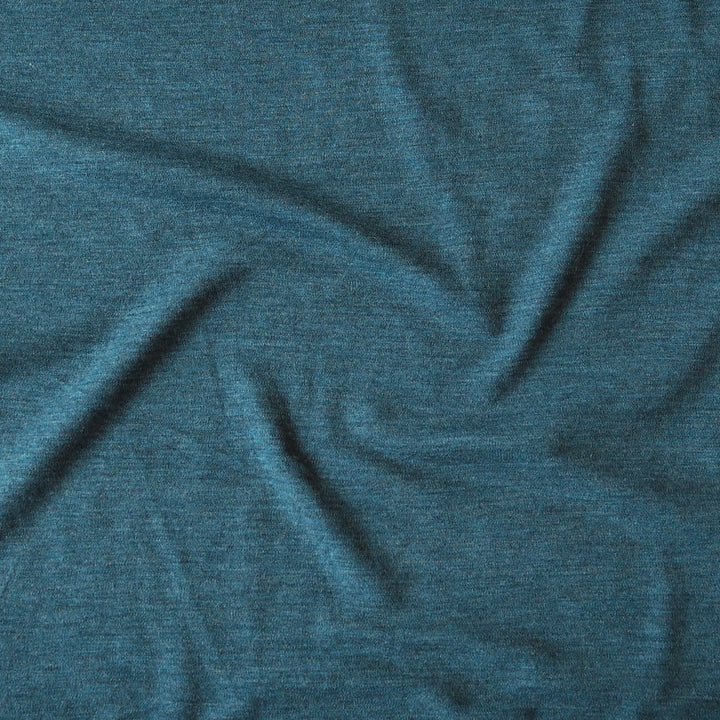 A close-up of textured heathered teal blue fabric with soft folds and wrinkles.