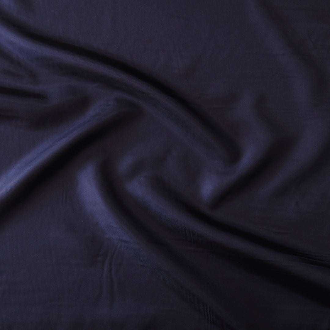 Dark navy blue fabric with a soft sheen, draped in elegant folds across the frame.