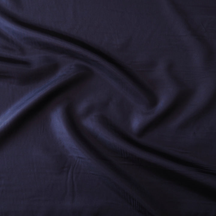 Dark navy blue fabric with a soft sheen, draped in elegant folds across the frame.