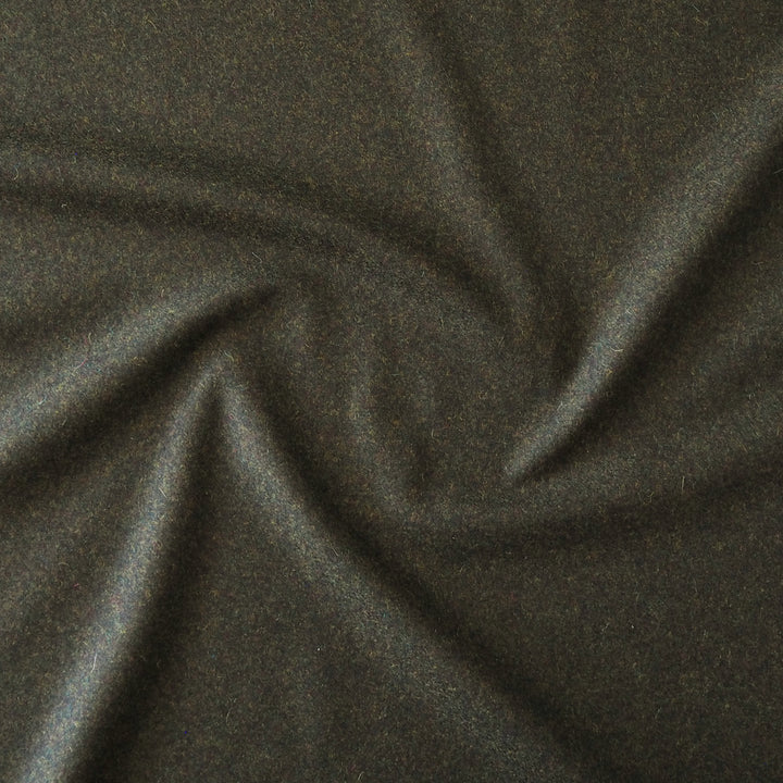 A close-up of dark charcoal green fabric with a soft, slightly textured surface, arranged in a gentle spiral drape.