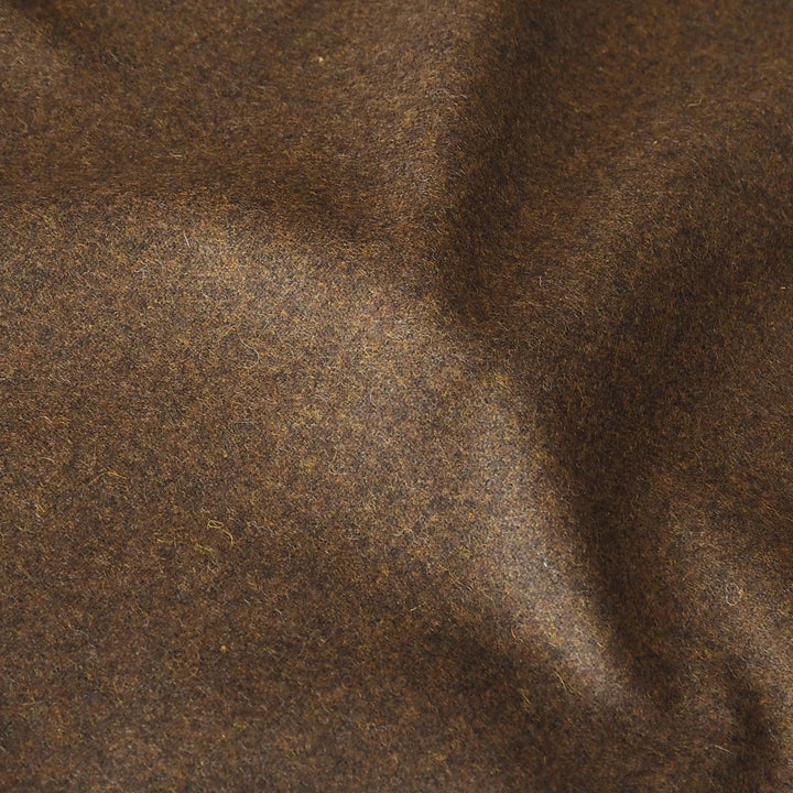 A close-up of dark brown textured fabric with a soft, slightly mottled surface and gentle folds.
