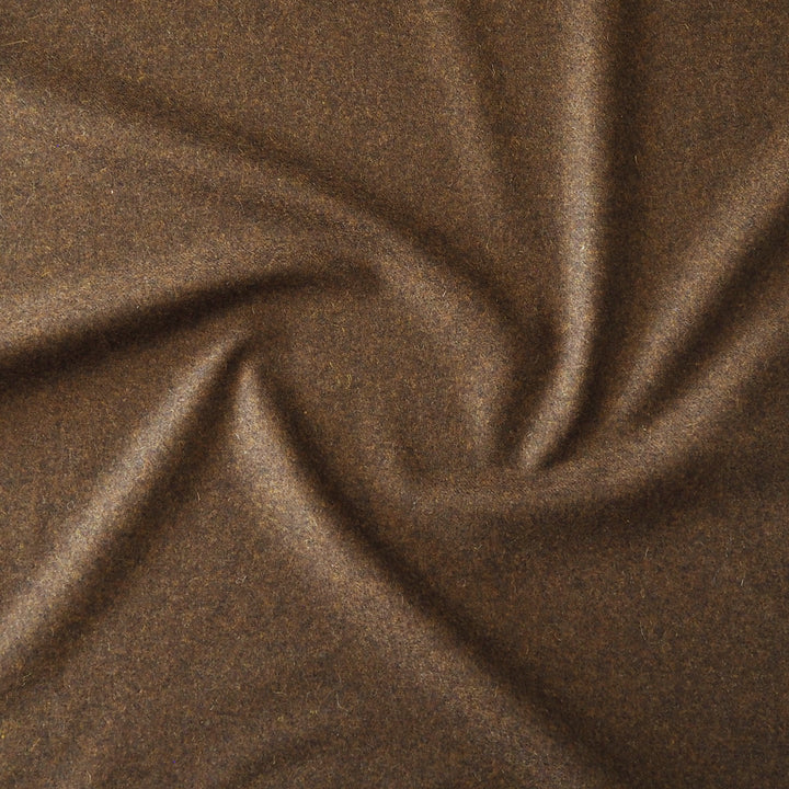 A close-up of draped brown fabric with a soft, slightly textured surface and gentle folds.