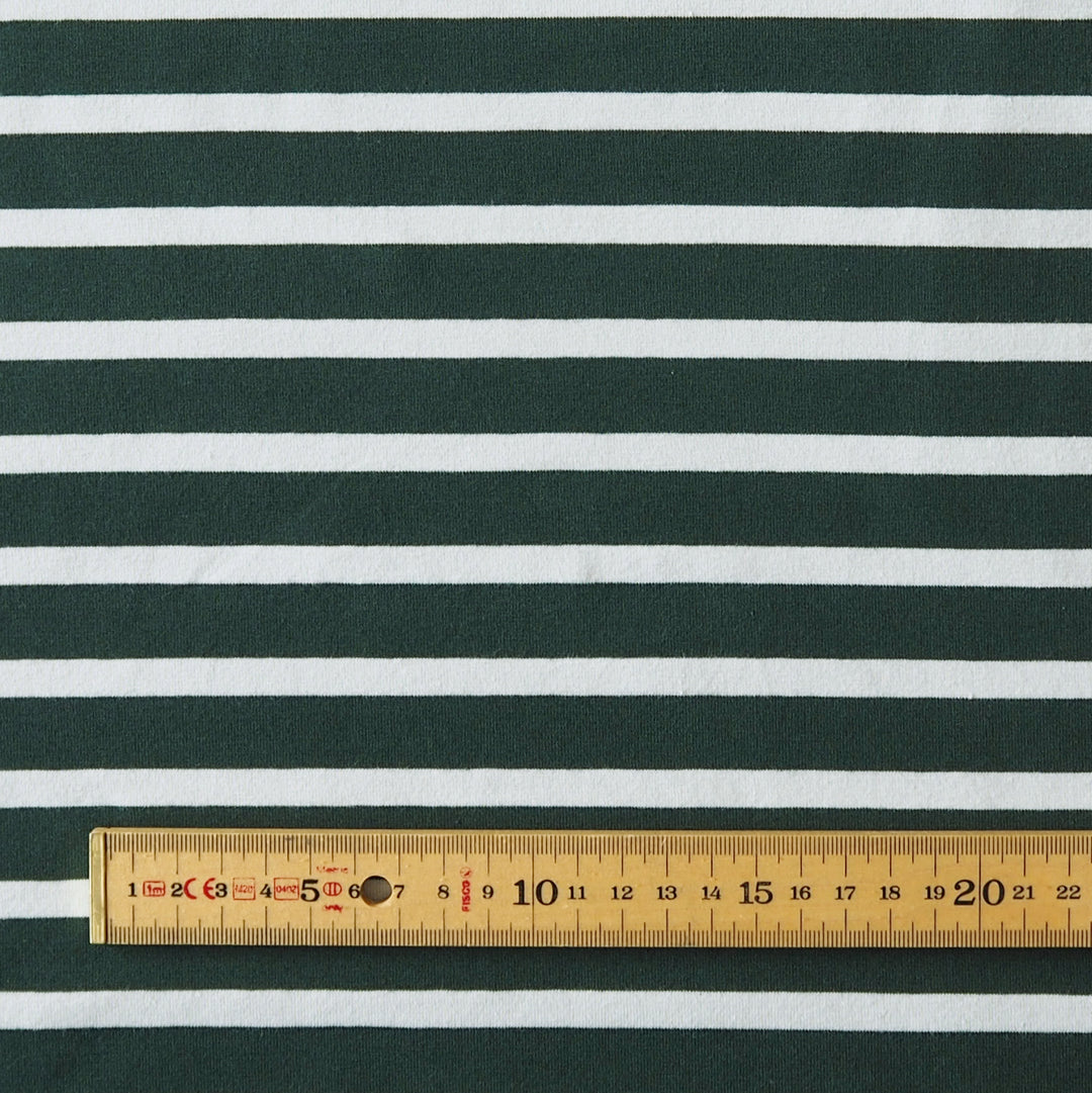 Dark green and mint horizontally striped fabric with a wooden ruler at the bottom showing the scale of the stripes.