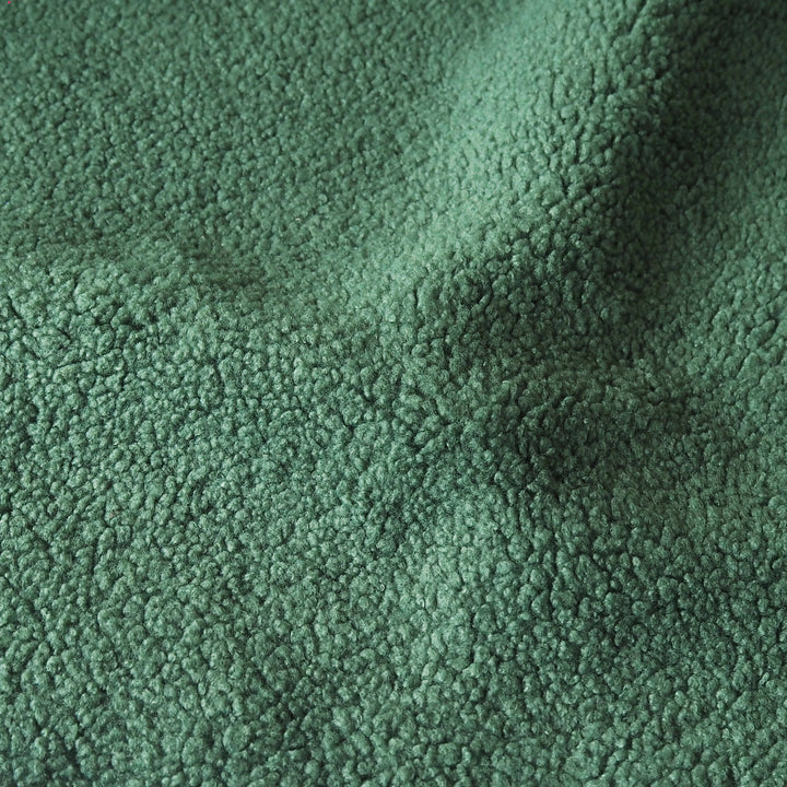 A close-up of a textured fleece fabric in a dusty sage green color, showing the soft, looped pile of the material.