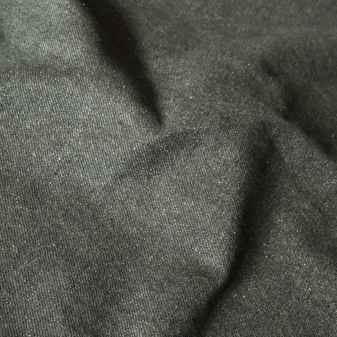 A close-up of dark charcoal gray fabric with a fine textured weave and soft folds.