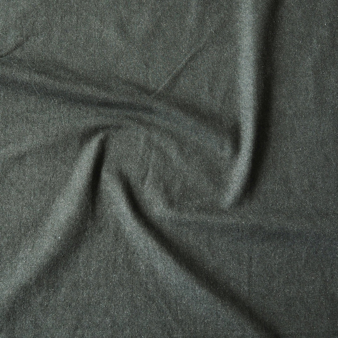 A close-up of dark charcoal gray fabric with soft folds and a slightly textured surface.