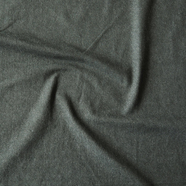 A close-up of dark charcoal gray fabric with soft folds and a slightly textured surface.