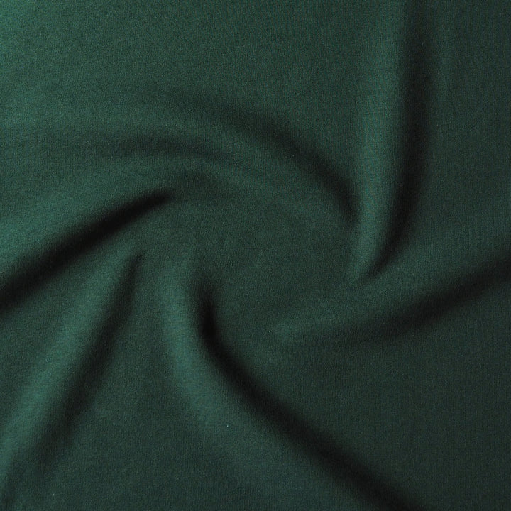 Dark forest green fabric with a soft, slightly textured surface, shown draped in a spiral pattern to highlight its drape and color.