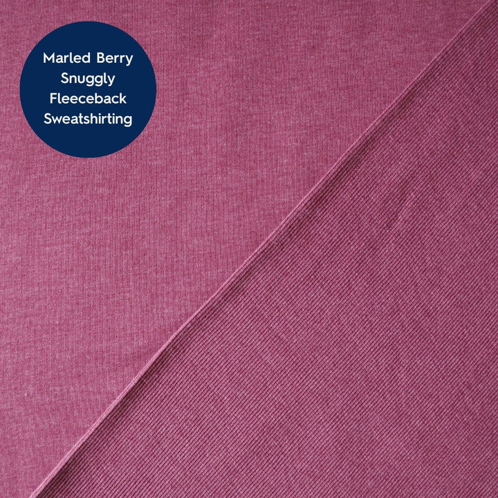 A close-up fabric swatch showing a marled berry pink fleece sweatshirt fabric, with a dark blue circular label in the top-left corner that reads 'Marled Berry Snuggly Fleeceback Sweatshirt'.